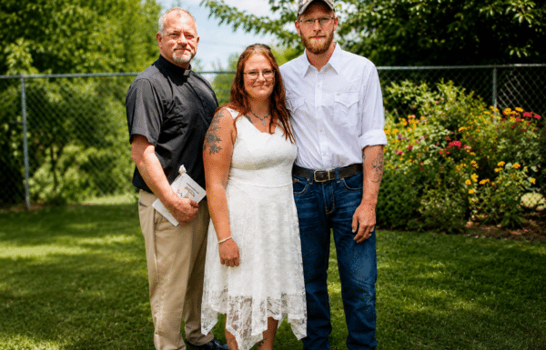 Wedding officiant John Johnson with a newly married couple following their outdoor Minnesota ceremony.